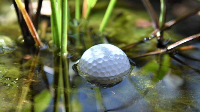 Regolfed Lakeballs Golfball liegt in einem Wasserhindernis