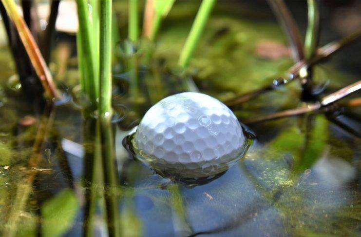 Golfball liegt in einem Wasserhindernis