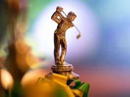 Golferfigur aus Gold auf einem Pokal